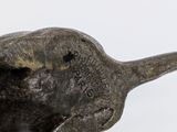 a bronze statue of a fish on a white surface