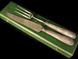 two knives and a fork in a green box
