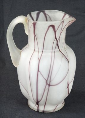 a white vase with red lines on it on a black background