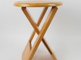 a small wooden table with two crossed legs on a white background