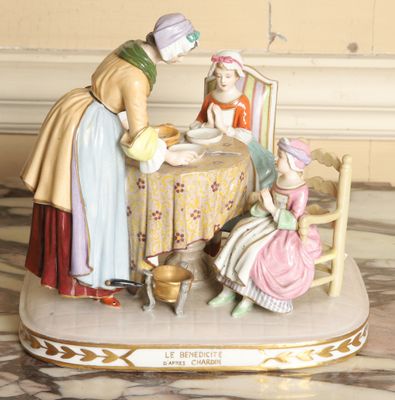 a figurine of a woman and two children sitting at a table
