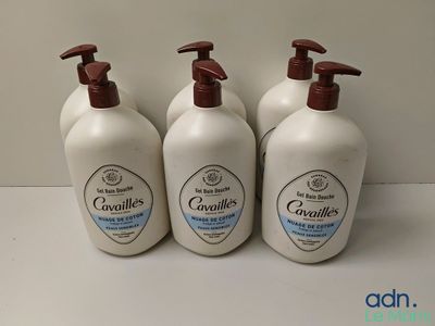 trois flacons de gel douche posés sur un plan de travail