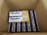 plusieurs boîtes de dentifrice Fixodent rangées dans un carton