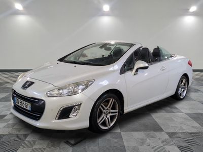 la voiture blanche est garée sur un sol en damier dans le garage