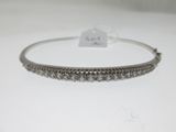 a silver bang bracelet with a row of diamonds on it