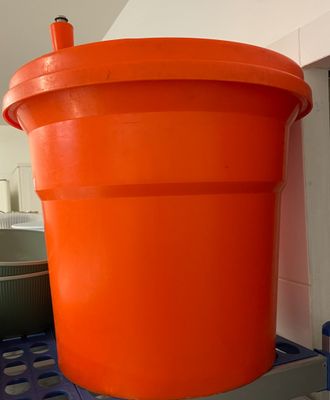 un grand seau orange posé sur une table bleue
