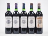 quatre bouteilles de vin sont alignées sur une surface blanche