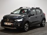 La voiture noire est garée dans la pièce au sol à carreaux.