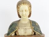 statue d'une femme vêtue d'une robe verte et blanche, posée sur un socle en bois