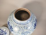 a blue and white vase with a lid sitting on a table