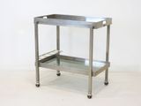 a stainless steel serving cart on wheels on a white floor