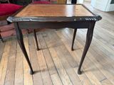 une petite table avec un plateau en bois sur un plancher en bois
