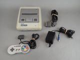 une console de jeux Nintendo Classic et un chargeur posés sur une table