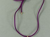 un gros plan sur un collier violet orné d'un cœur