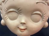 a close up of a doll head on a table