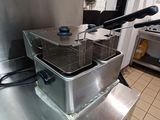 deux friteuses posées sur un plan de travail dans une cuisine