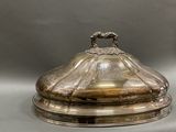 a silver plate with a bird on it on a table