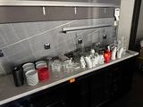 many cups and glasses on the counter in the kitchen