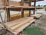 several pieces of wood are stacked on top of each other in front of a building