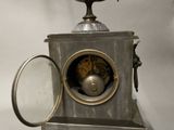 a silver clock with a bird on top of it