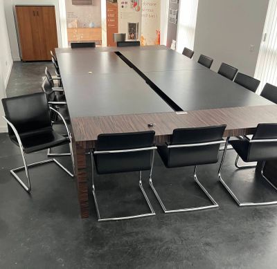 a long table with chairs around it in a conference room