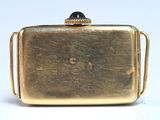 a gold purse that is sitting on a white surface