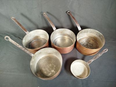 several pots and pans are lined up on a table