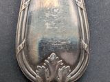 an old silver spoon sitting on top of a black table