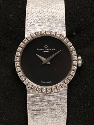 une image d'un gros plan d'une montre-bracelet sur une surface noire
