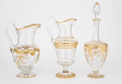 trois vases en verre ornés de motifs dorés, disposés les uns à côté des autres