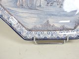 a blue and white plate with a picture of a group of people on it