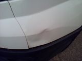 a white car that has a dent in the front of it