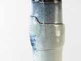 a blue and white vase with a black lid
