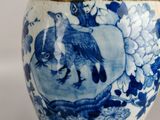 a blue and white vase with a bird on it