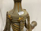 a gold vase on a stand with a label on it