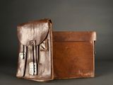 brown leather briefcase with three compartments on a dark background