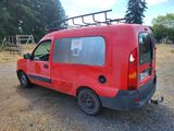 a red van parked in a lot with a ladder on the roof