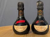 two bottles of wine sitting on top of a wooden table