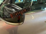 a guitar stuck in the side view mirror of a car