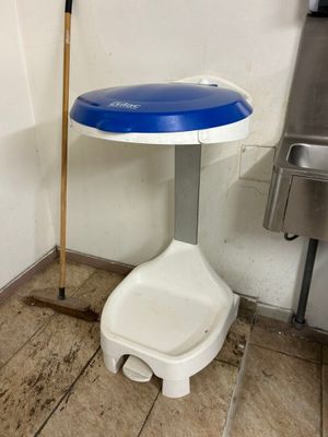 des toilettes avec un siège bleu à côté d'une poubelle