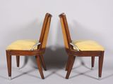 two wooden chairs with yellow upholstered seats and a white background