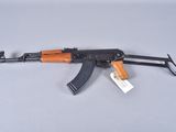 an akm machine gun with a wooden handle and a tag attached to it