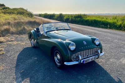 une voiture verte garée sur le bord de la route