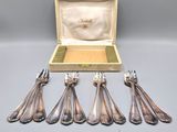 six silver spoons in a box with a case on a table