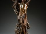 a bronze statue of a man holding a bird in his hand