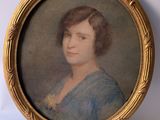 an old picture of a woman in a blue dress in a gold frame