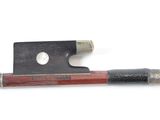 a violin bow with a wooden handle on a white surface