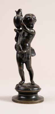 a small statue of a boy holding a bird on a pedestal