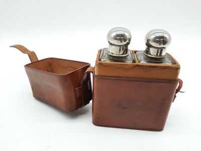 deux salières et poivrières dans un étui en cuir avec une cuillère