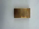 an image of a gold cigarette case sitting on a white surface